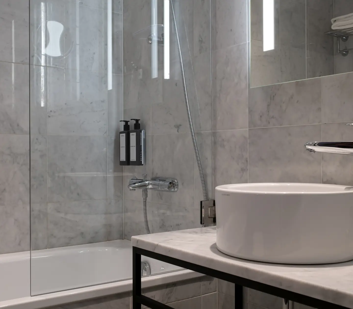Bright bathroom with sink, mirror and bathtub