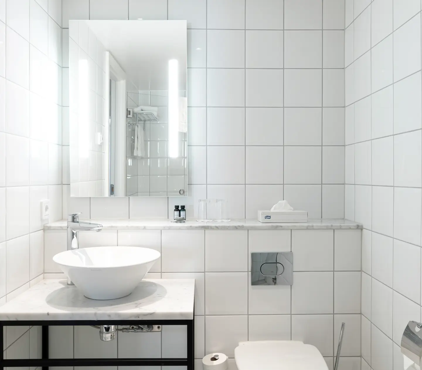 Bright bathroom with sink, mirror and toilet