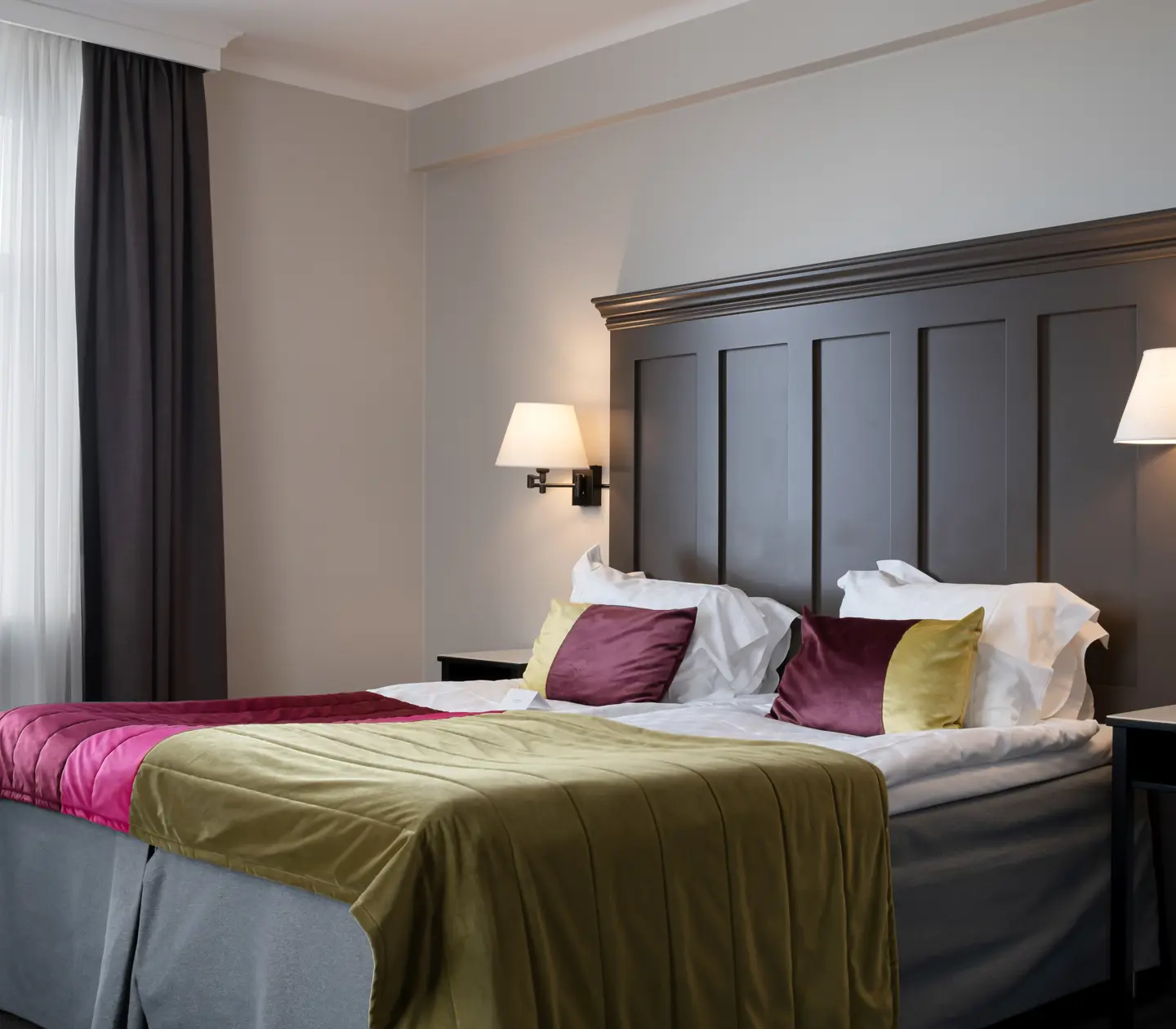 Hotel room with bed, large wooden headboard and sea view