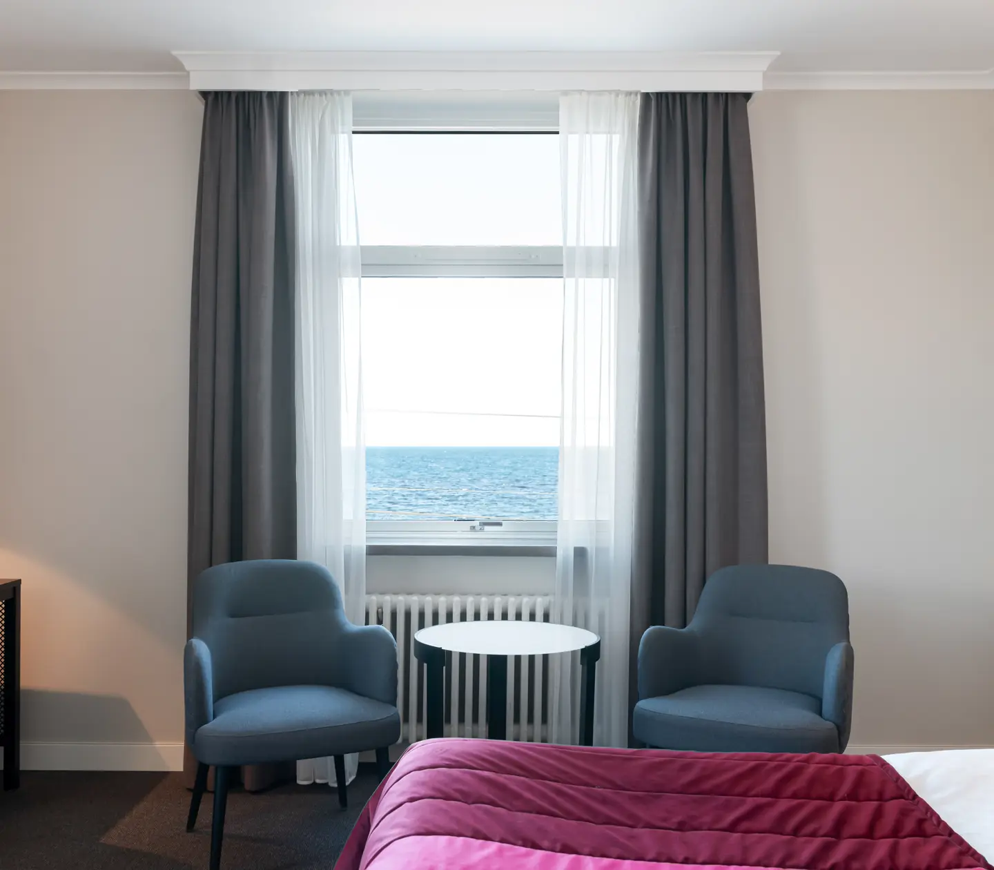 Hotel room with bed, armchairs and sea view