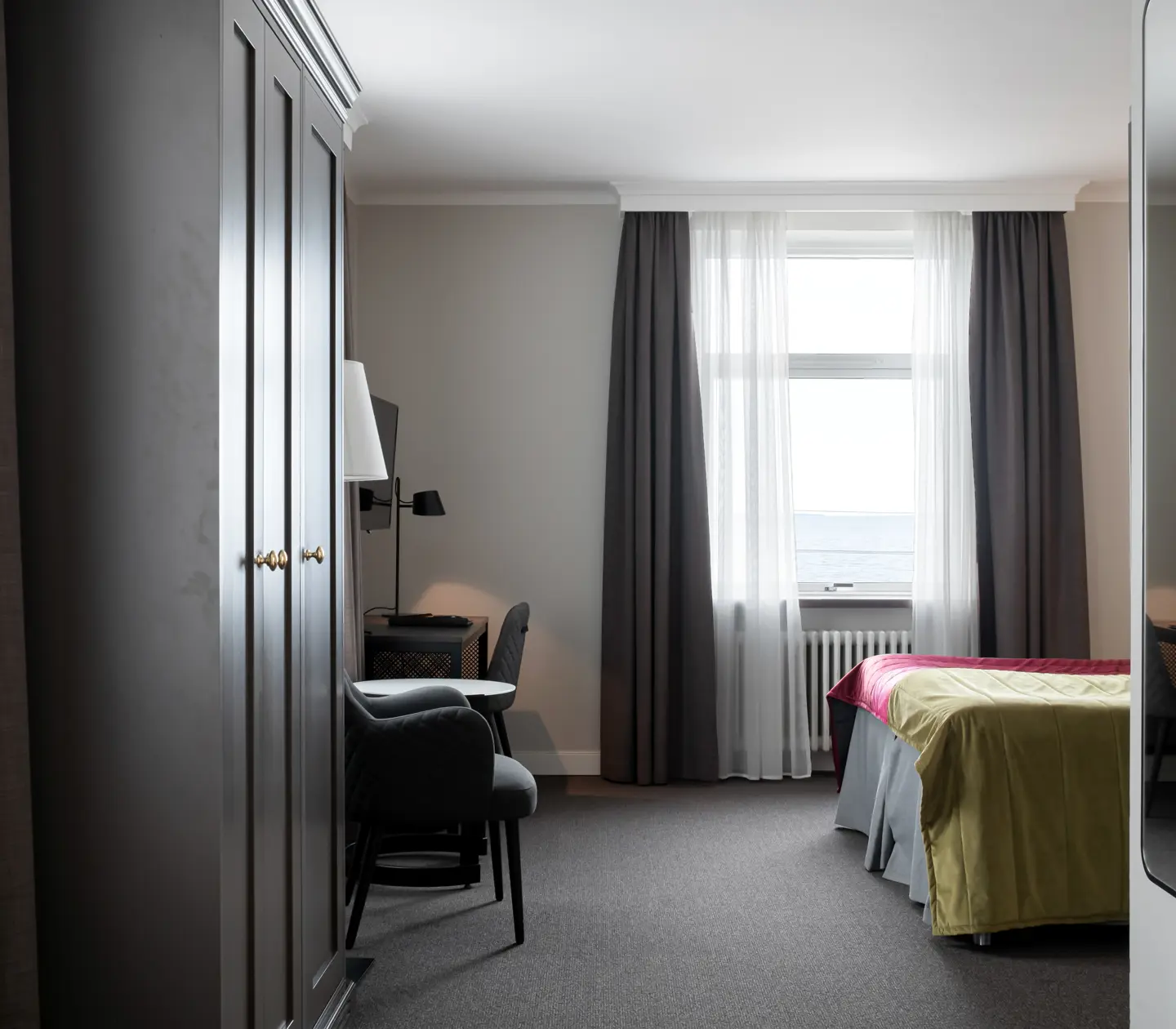 Hotel room with bed, wardrobe and sea view