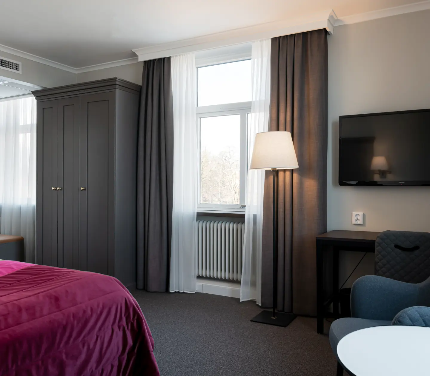 Hotel room with desk, window and wardrobe
