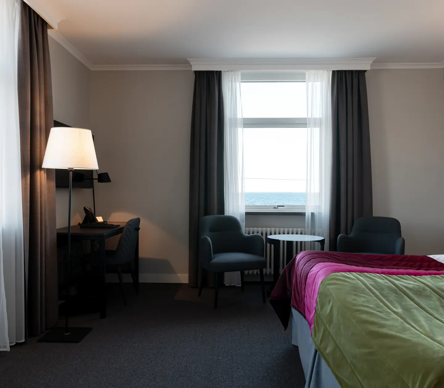 Hotel room with bed, armchairs and desk