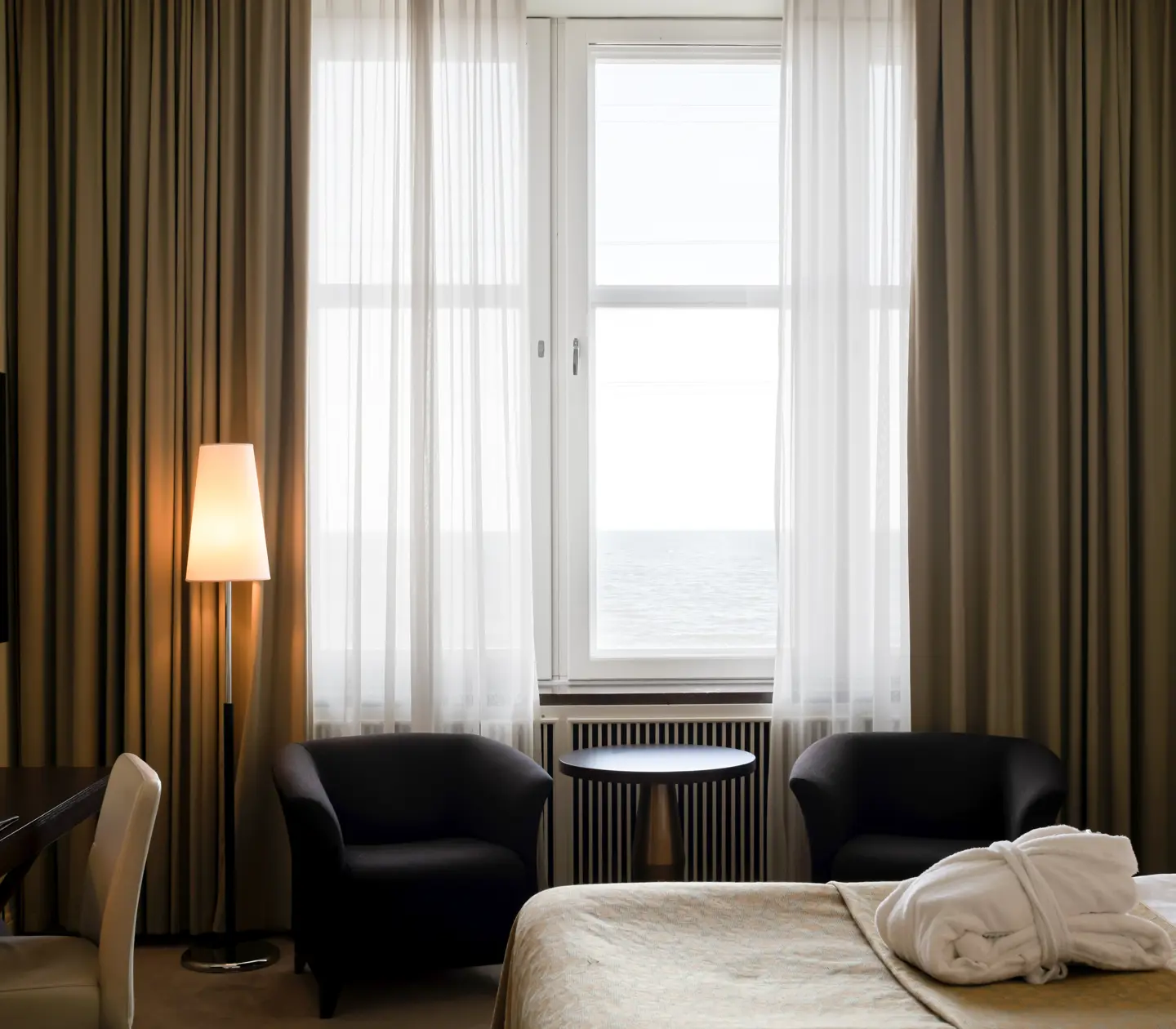 Hotel room with bed, armchairs and sea view