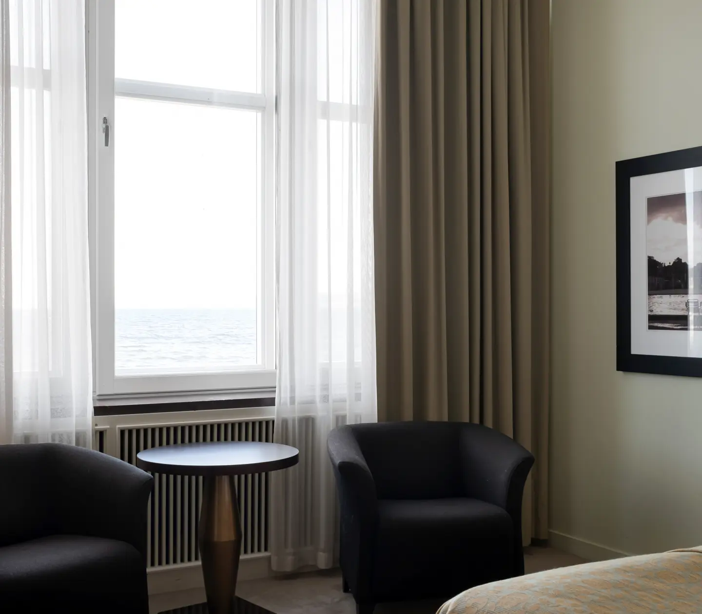 Hotel room with armchairs, blackboard and sea view