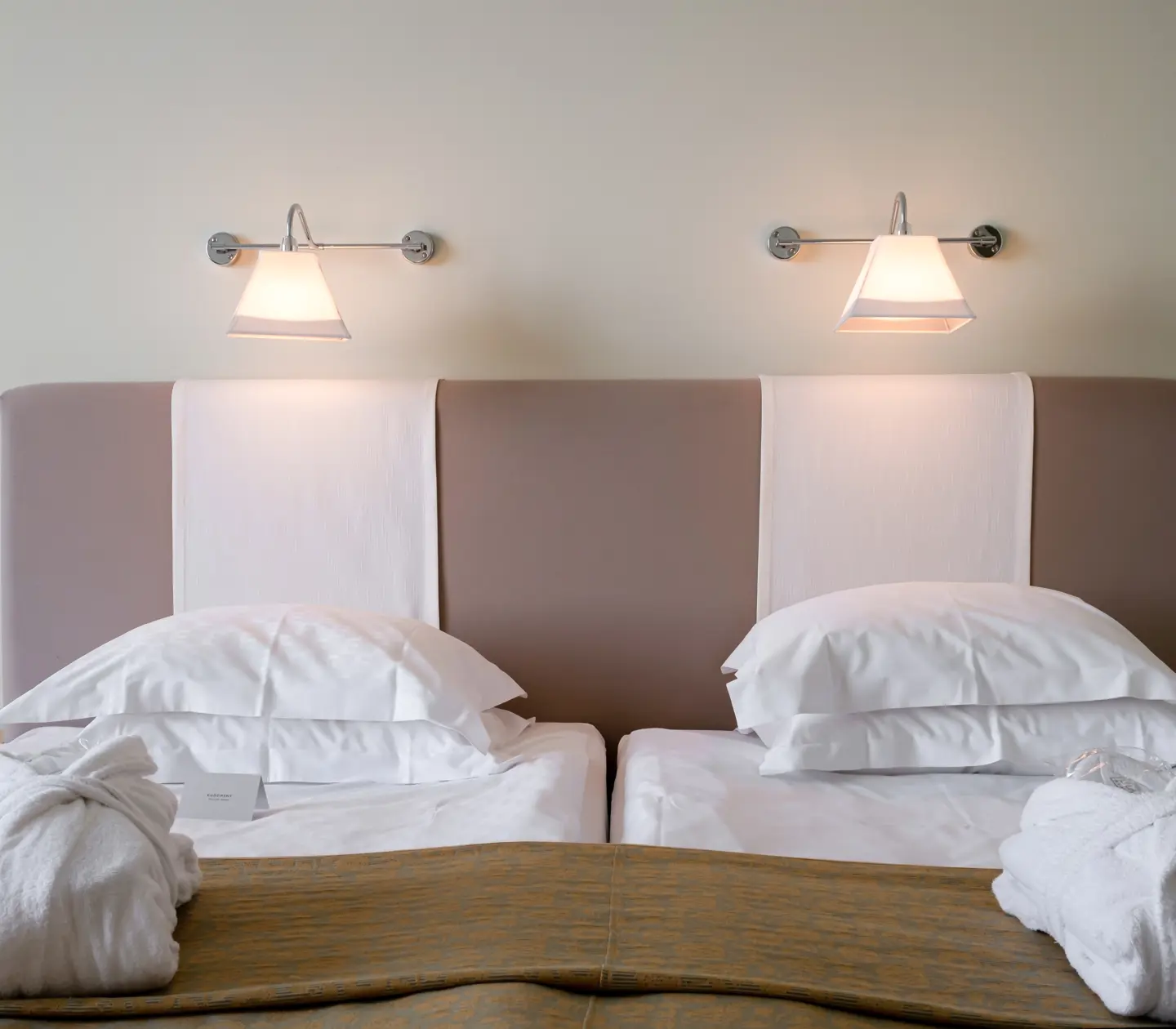 Hotel room with bed, headboard and bedside lamps