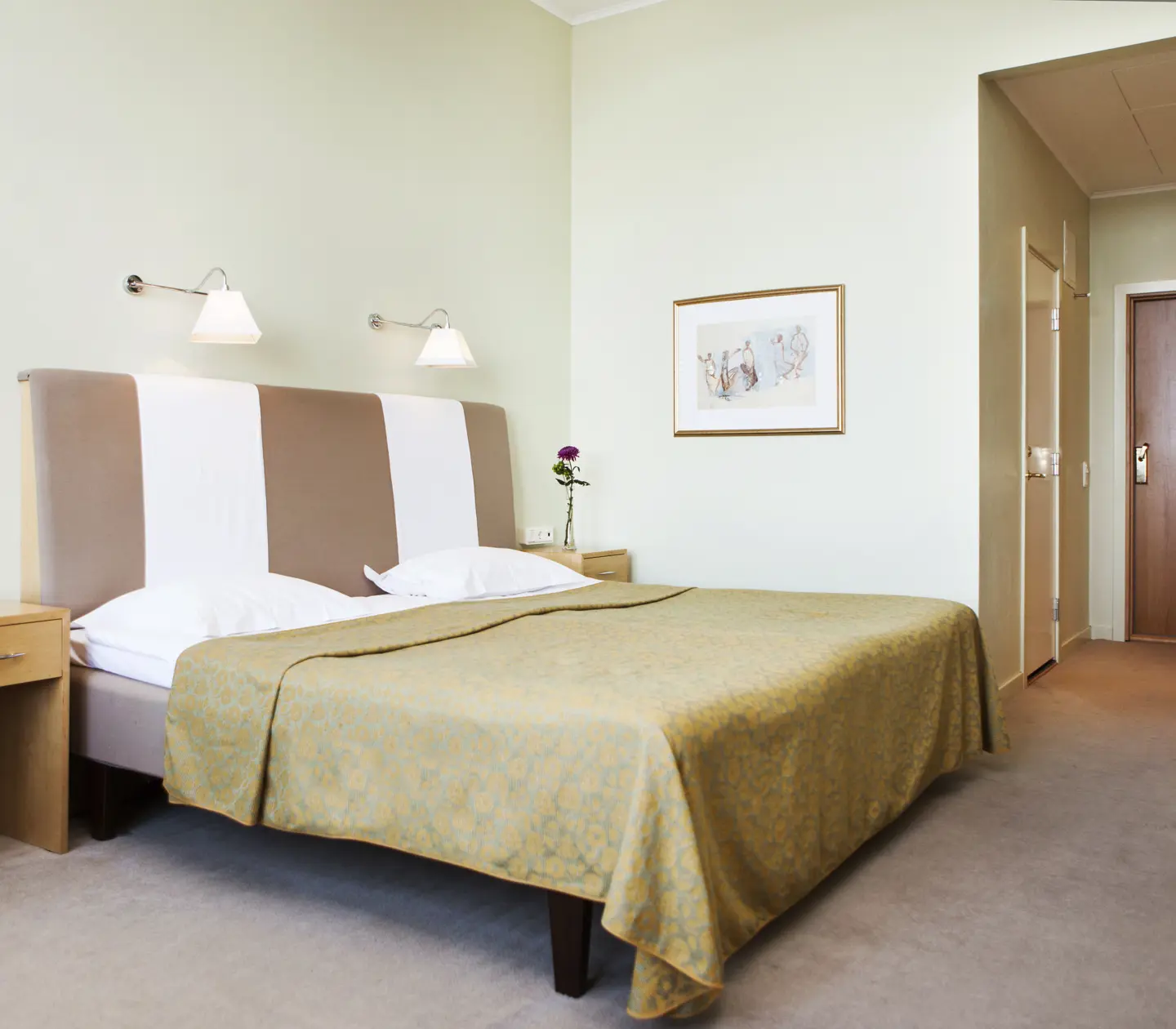 Hotel room with bed, large headboard and bedside table