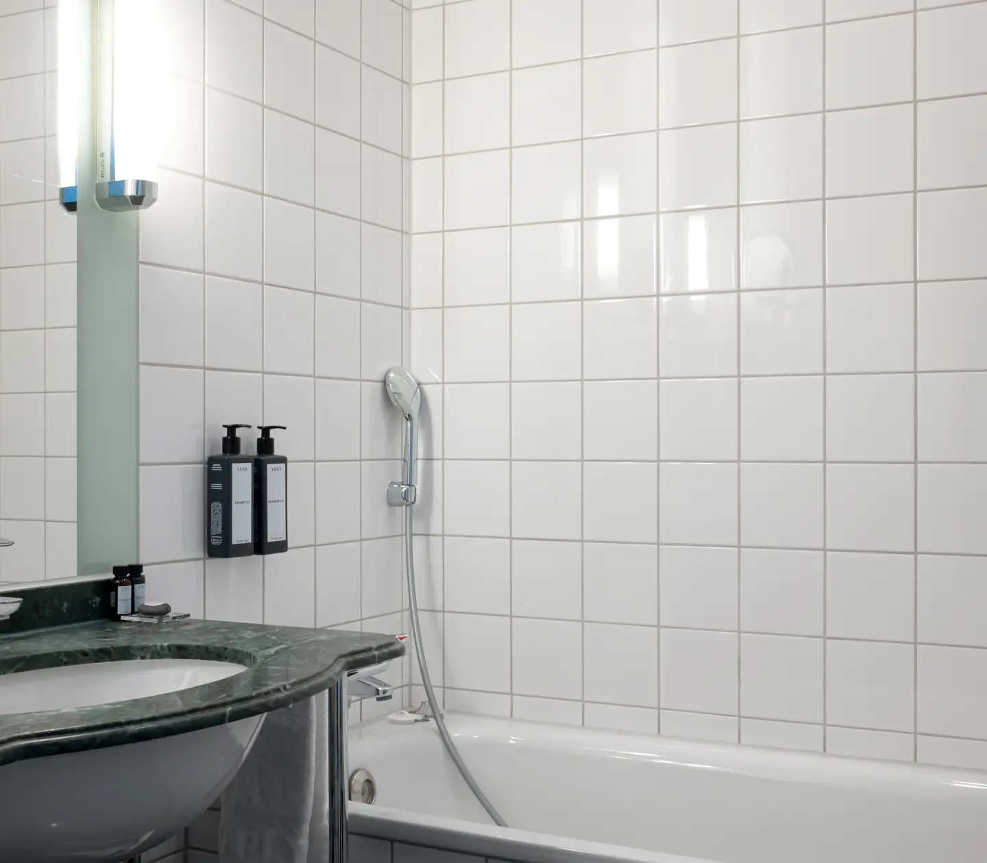 Bright bathroom with bathtub, sink and mirror
