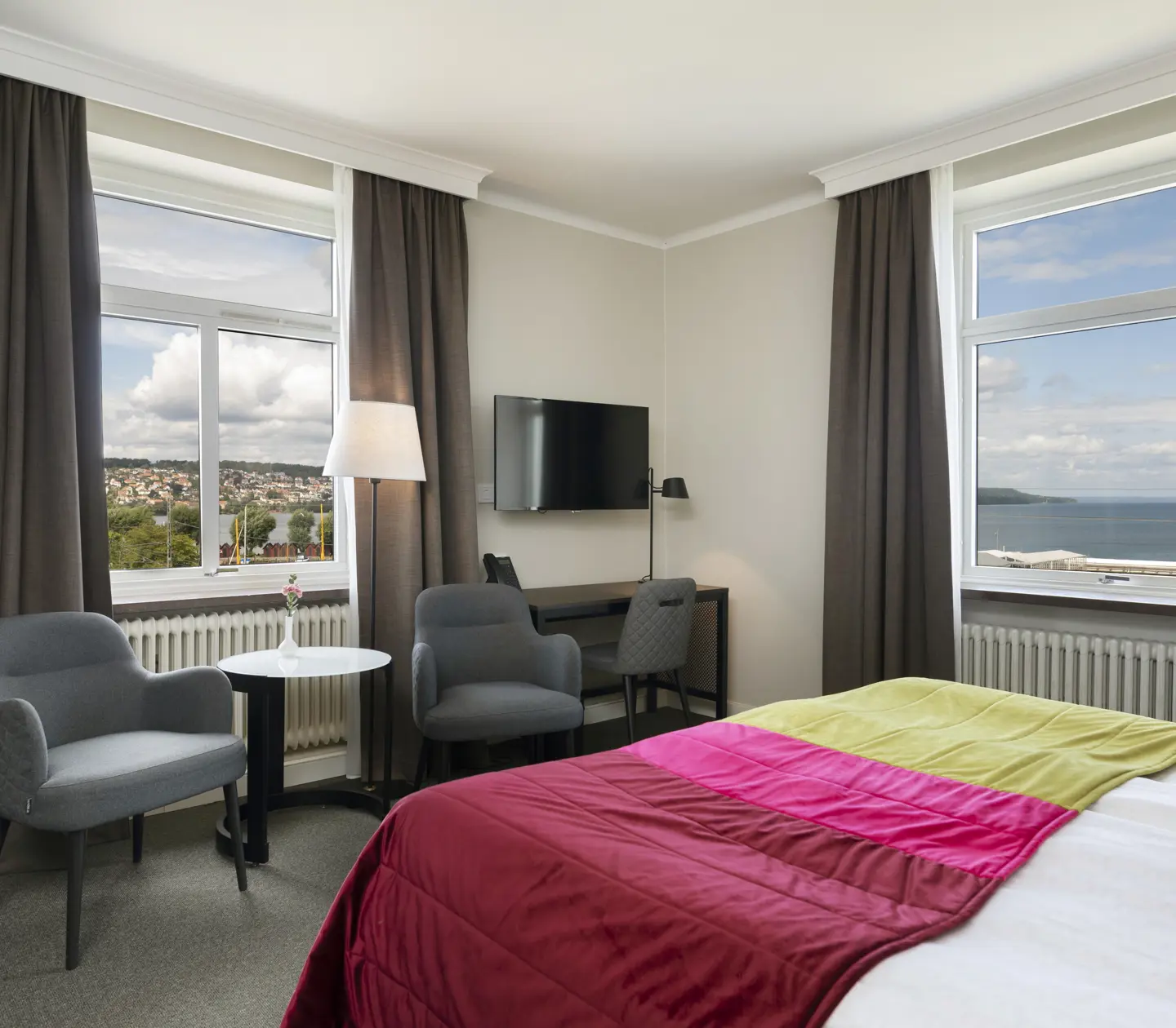Hotel room with bed, armchairs and sea view