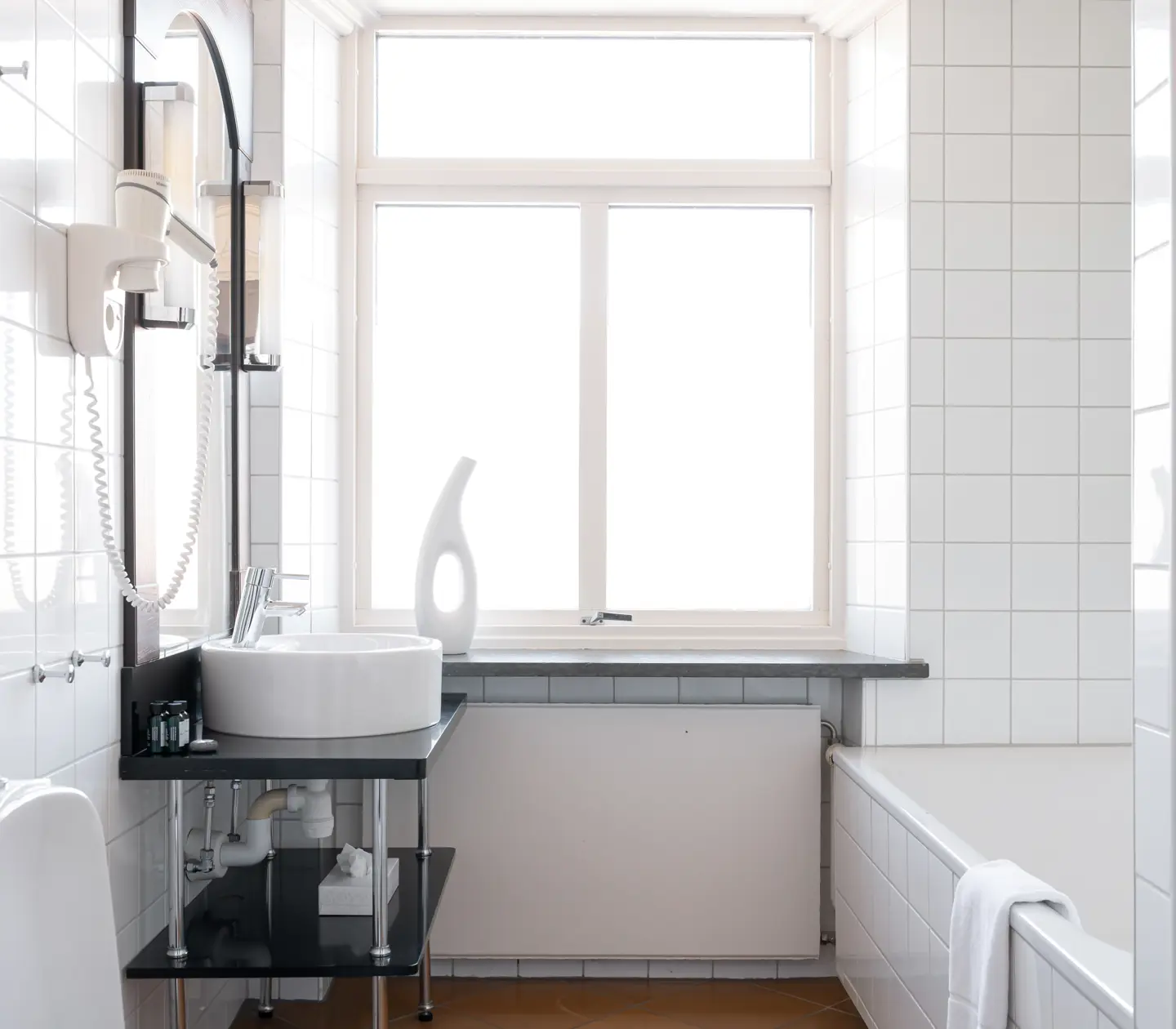 Bright bathroom with sink, window and bathtub