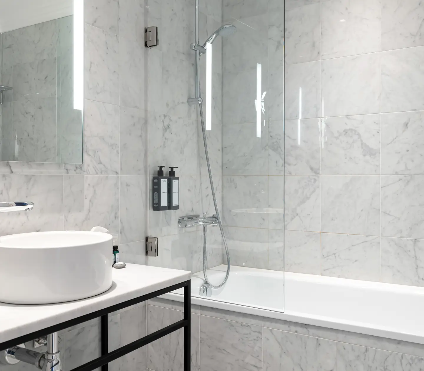 Bright bathroom with bathtub, sink and mirror