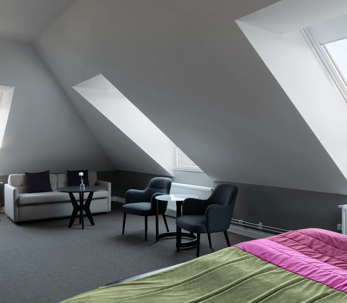 Hotel room with armchairs, sofa and sloping ceiling