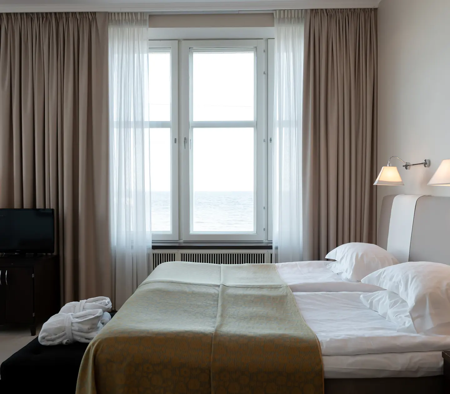 Suite with bed, TV and large window