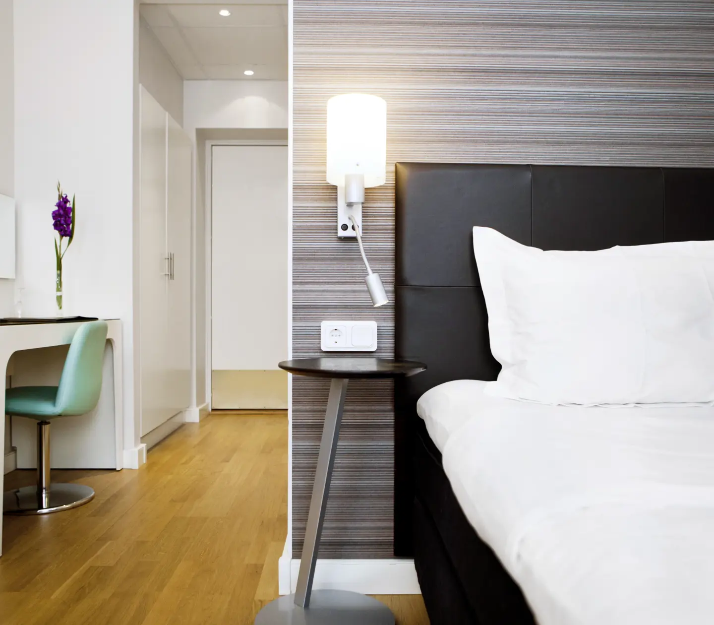 Hotel room with single bed, lamps and desk