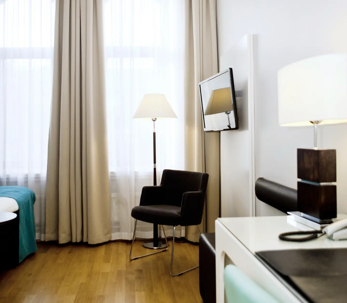 Hotel room with armchair, floor lamp and TV