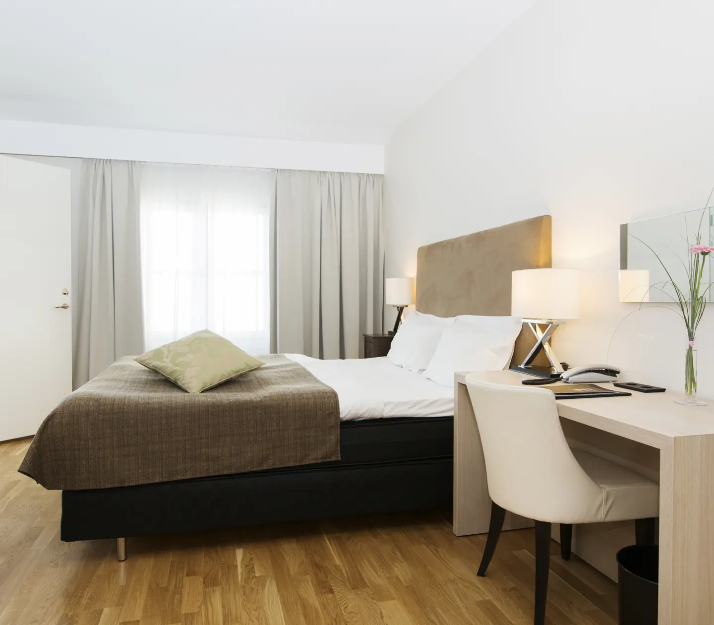 Hotel room with double bed, desk and window