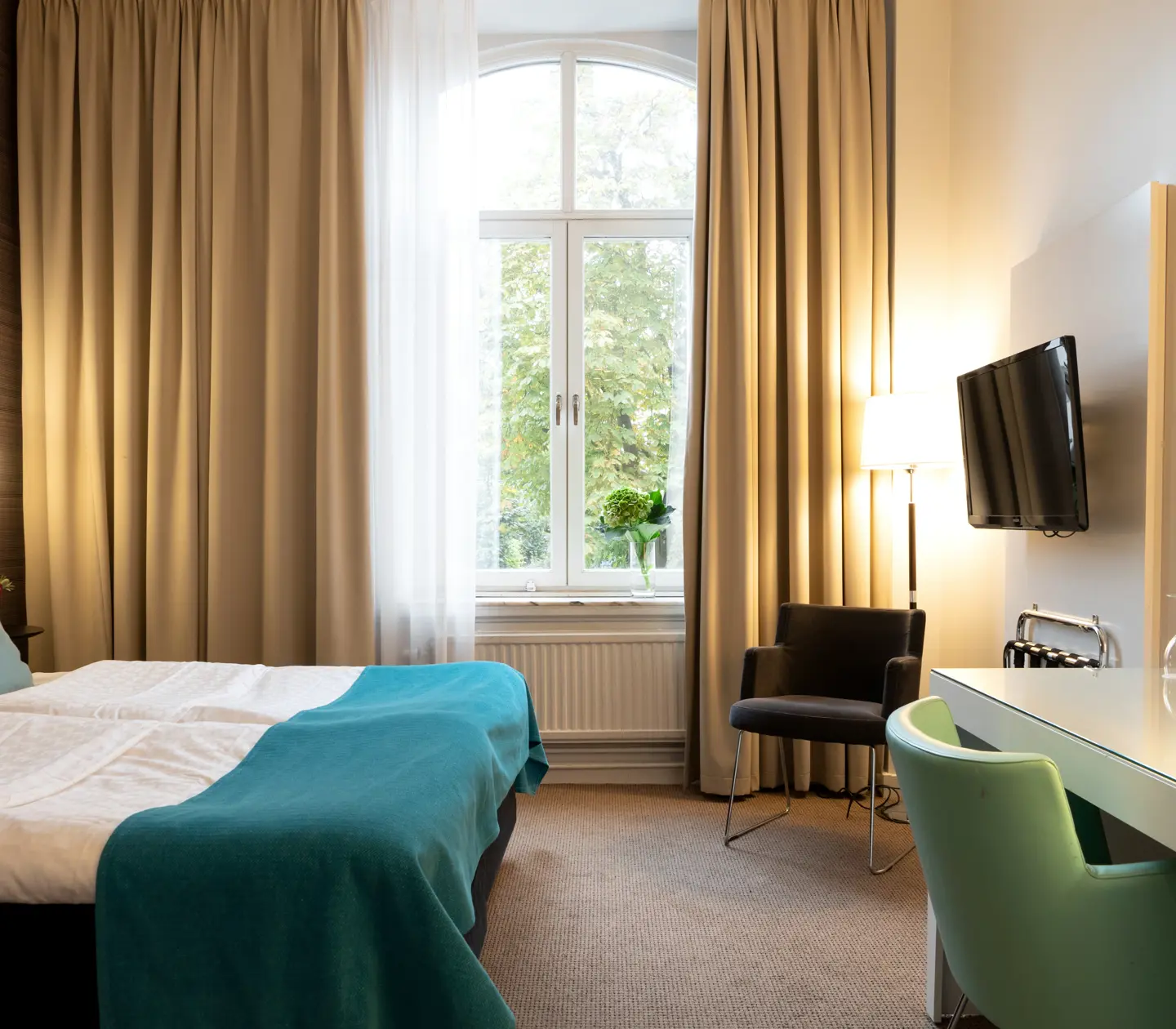 Hotel room with double bed, desk and large window