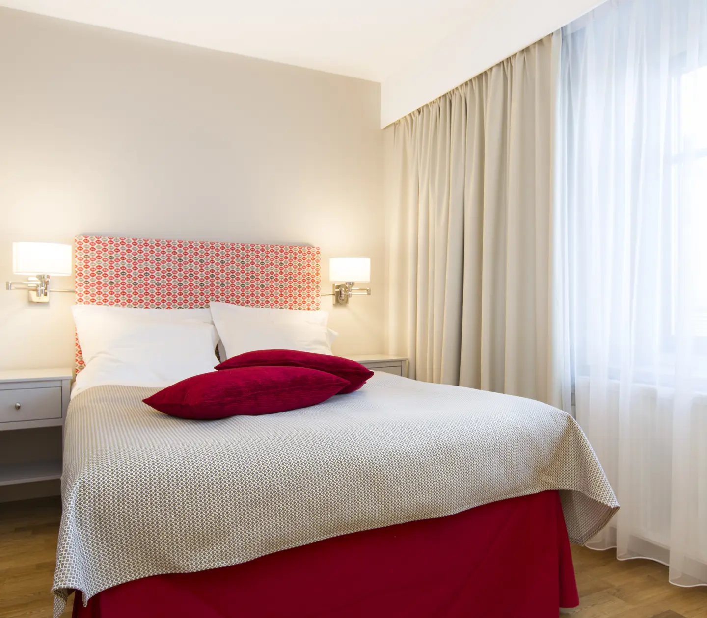 Hotel room with double bed, bedside lamps and window