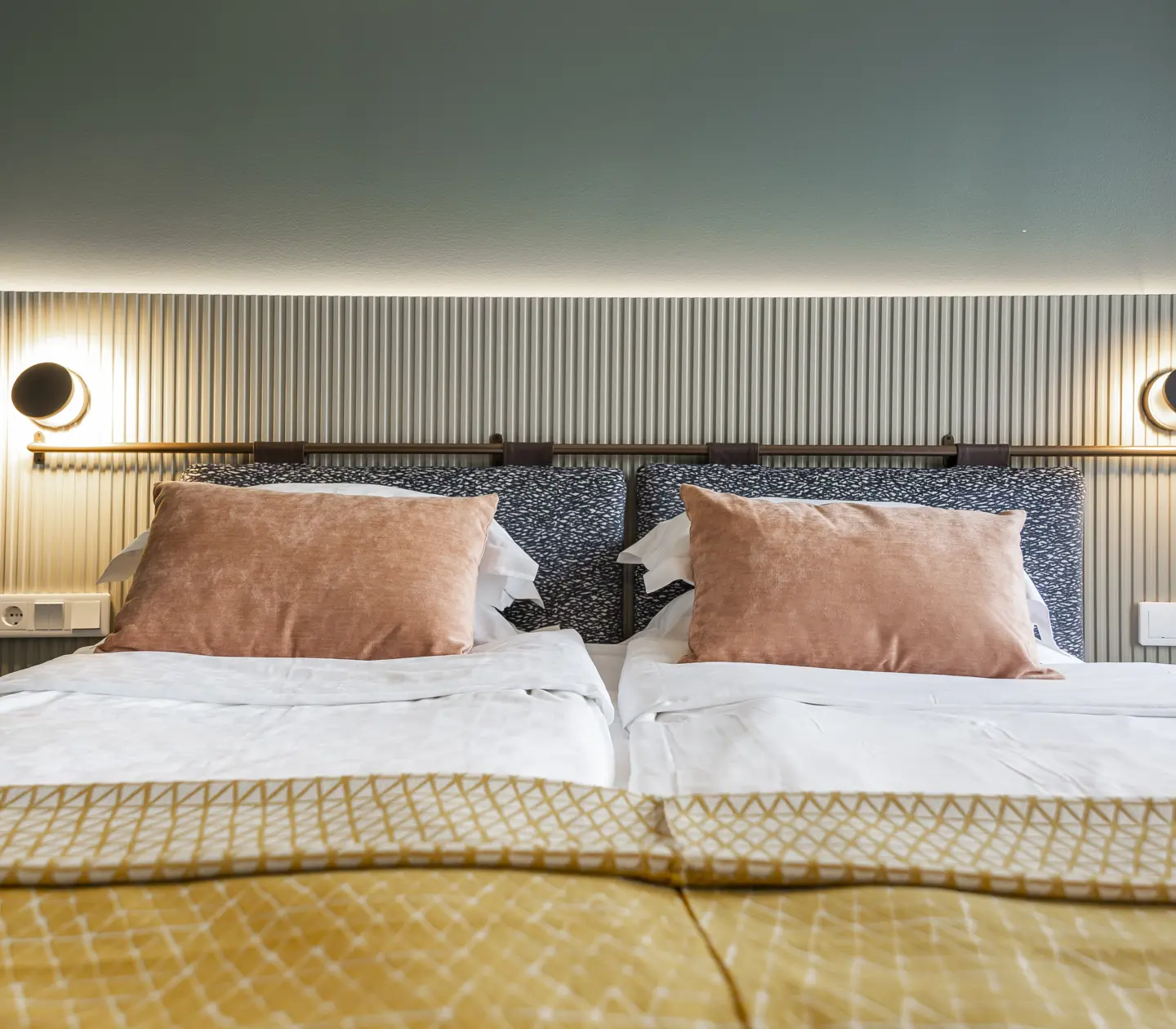 Comfortable hotel room with double bed, warm textiles and bedside lamps
