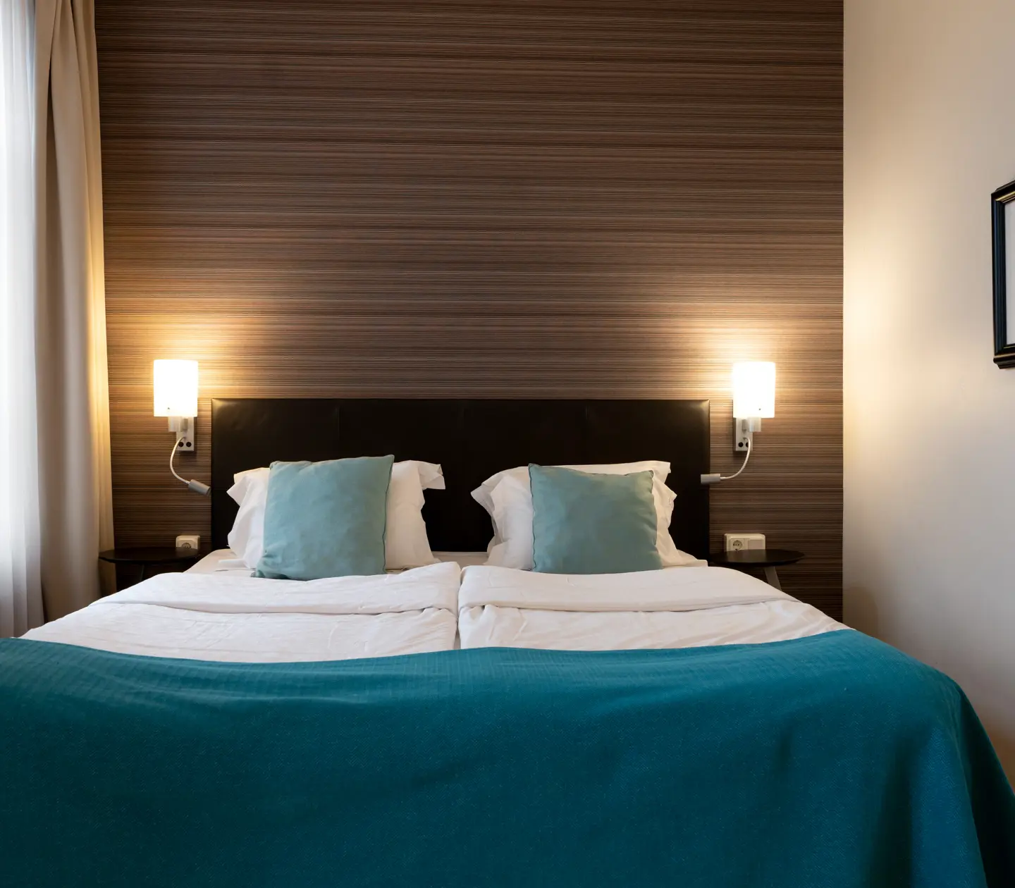 Hotel room with double bed, bedside lamps and window