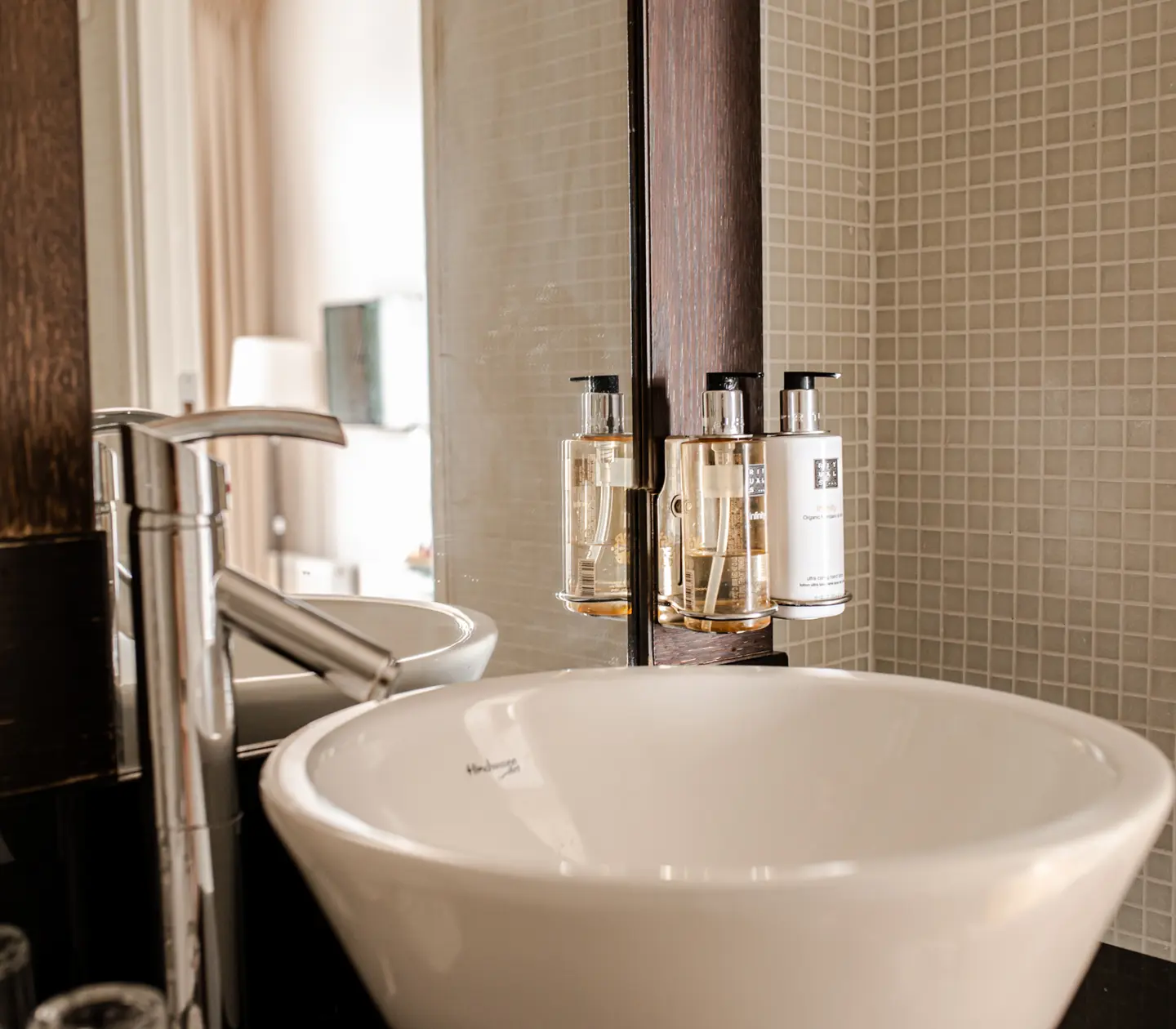 Bright bathroom with sink, mirror and soaps