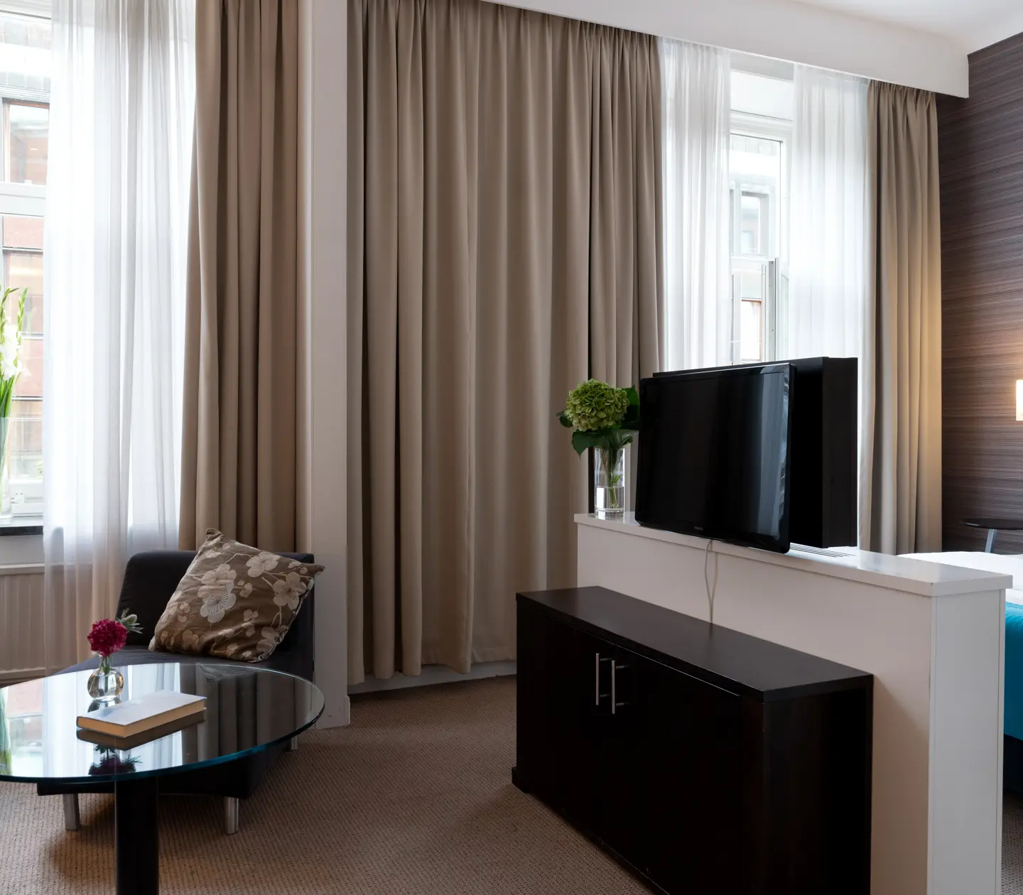 Hotel room with double bed, TV and large windows