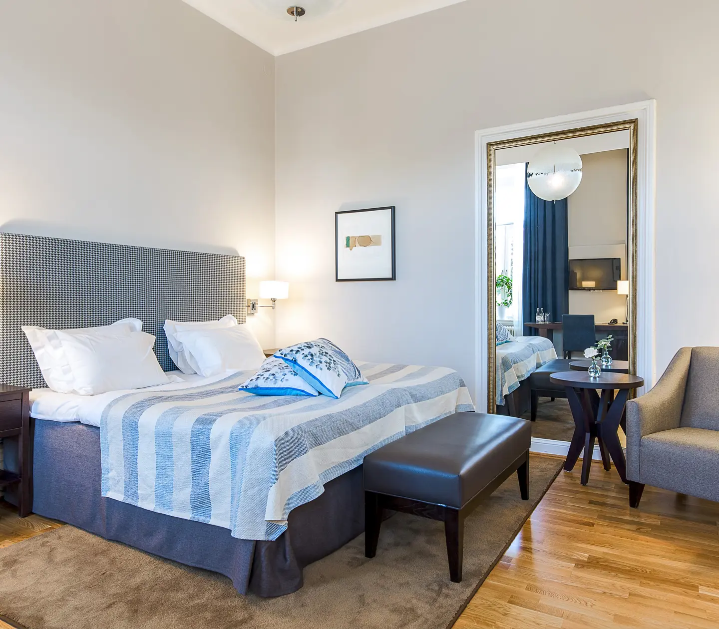 Bright suite with double bed, blue textiles and large mirror