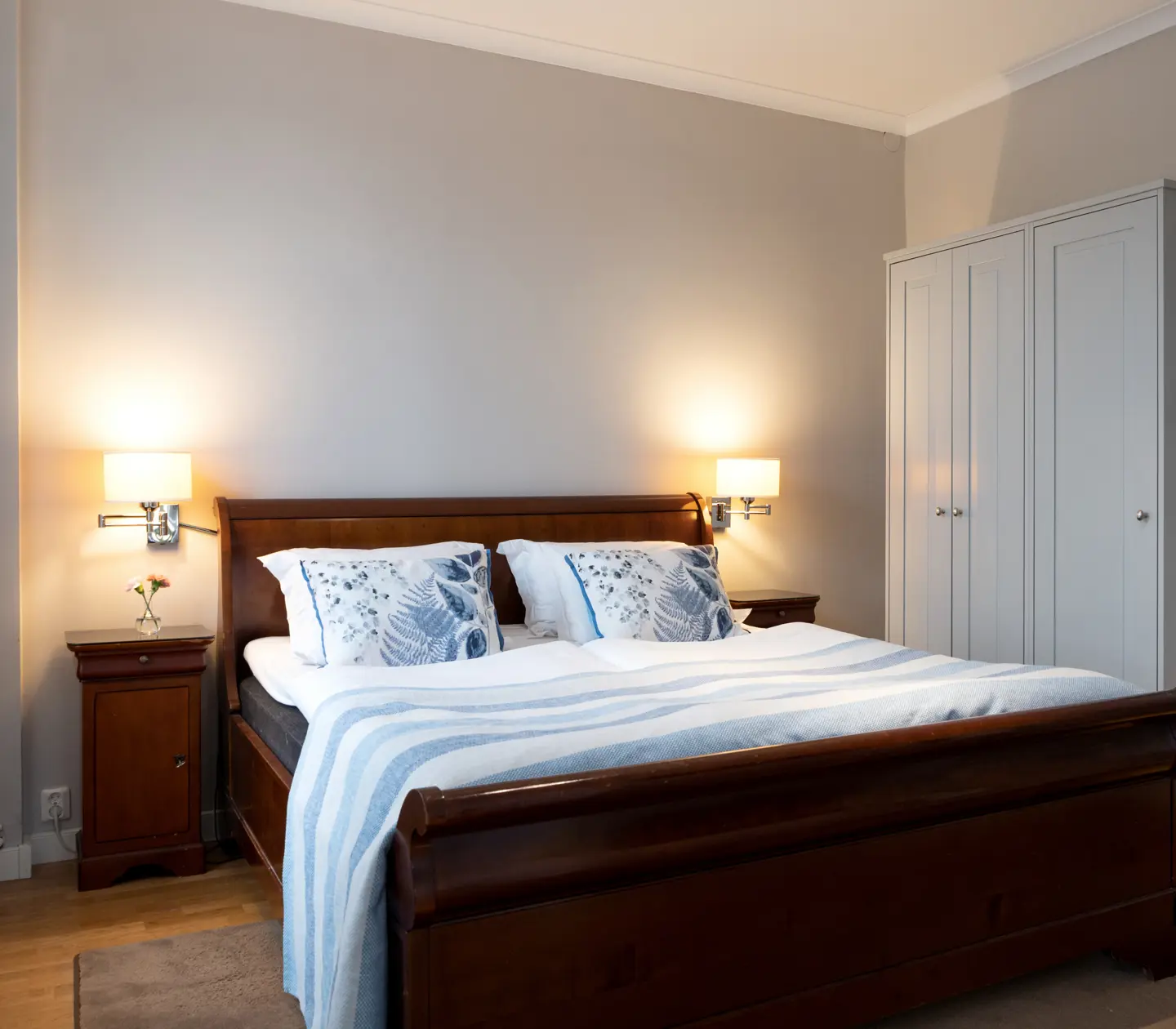 Bright suite with blue textiles, double bed and wardrobe