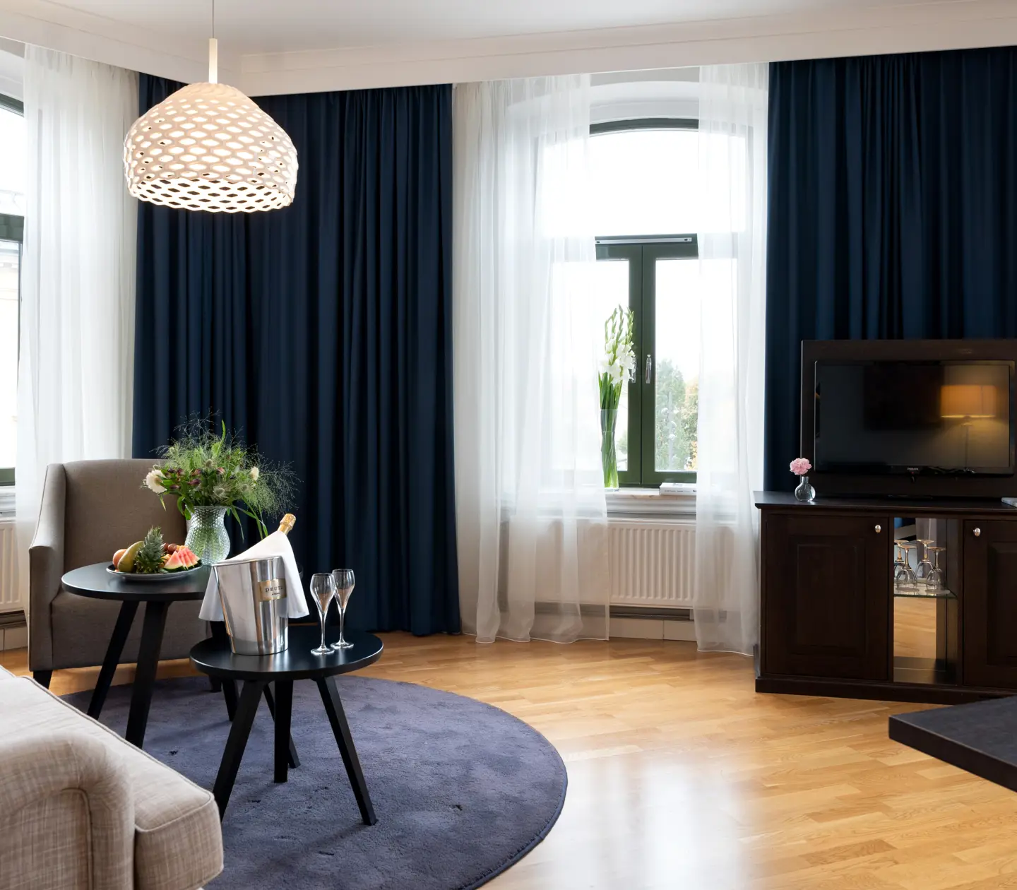 Cozy suite with sofa, TV and large windows