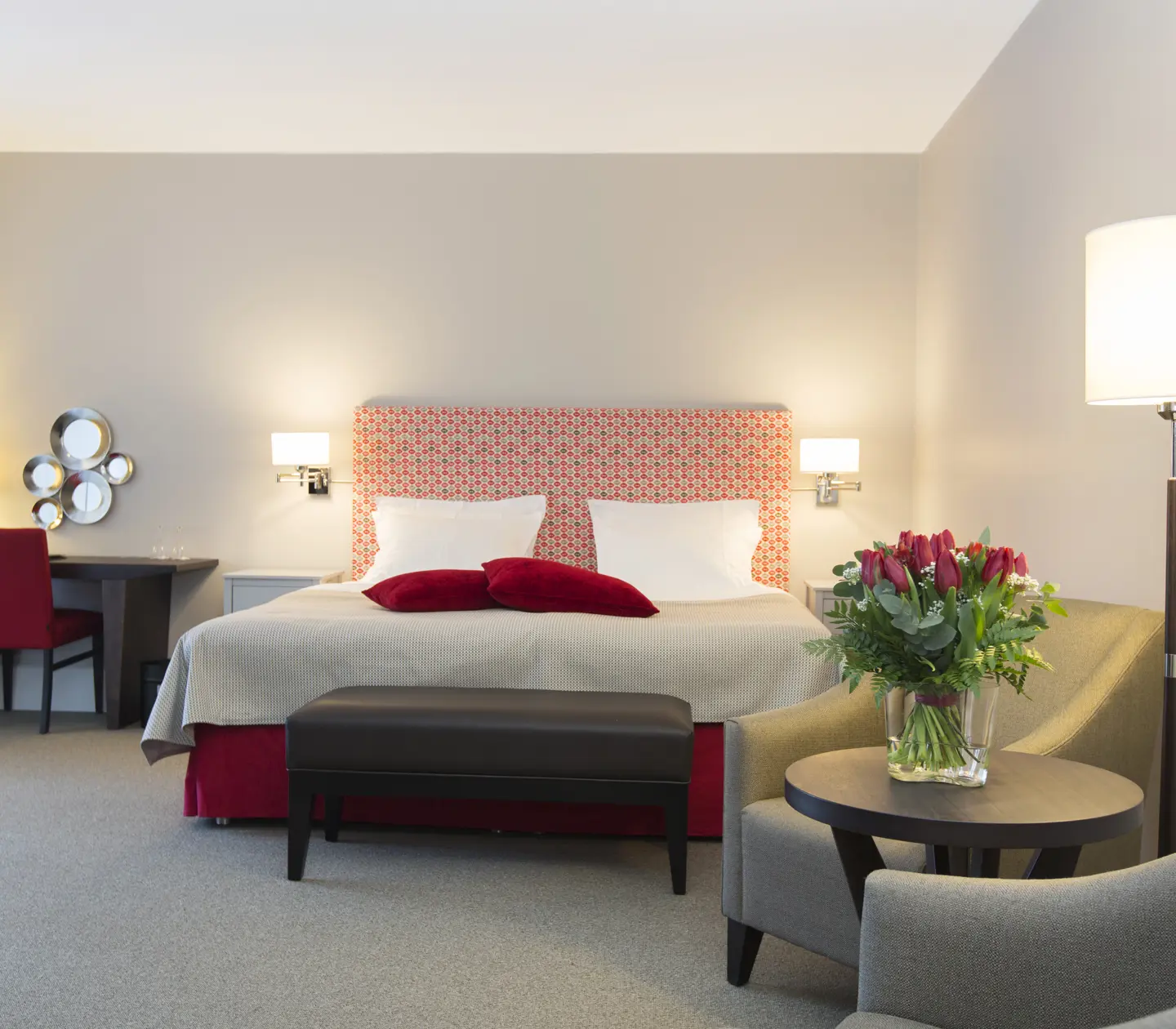 Bright suite with bed, desk and rose bouquet