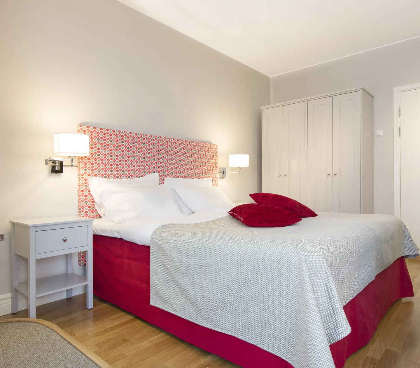 Bright suite with bed, wardrobe and bedside lamps