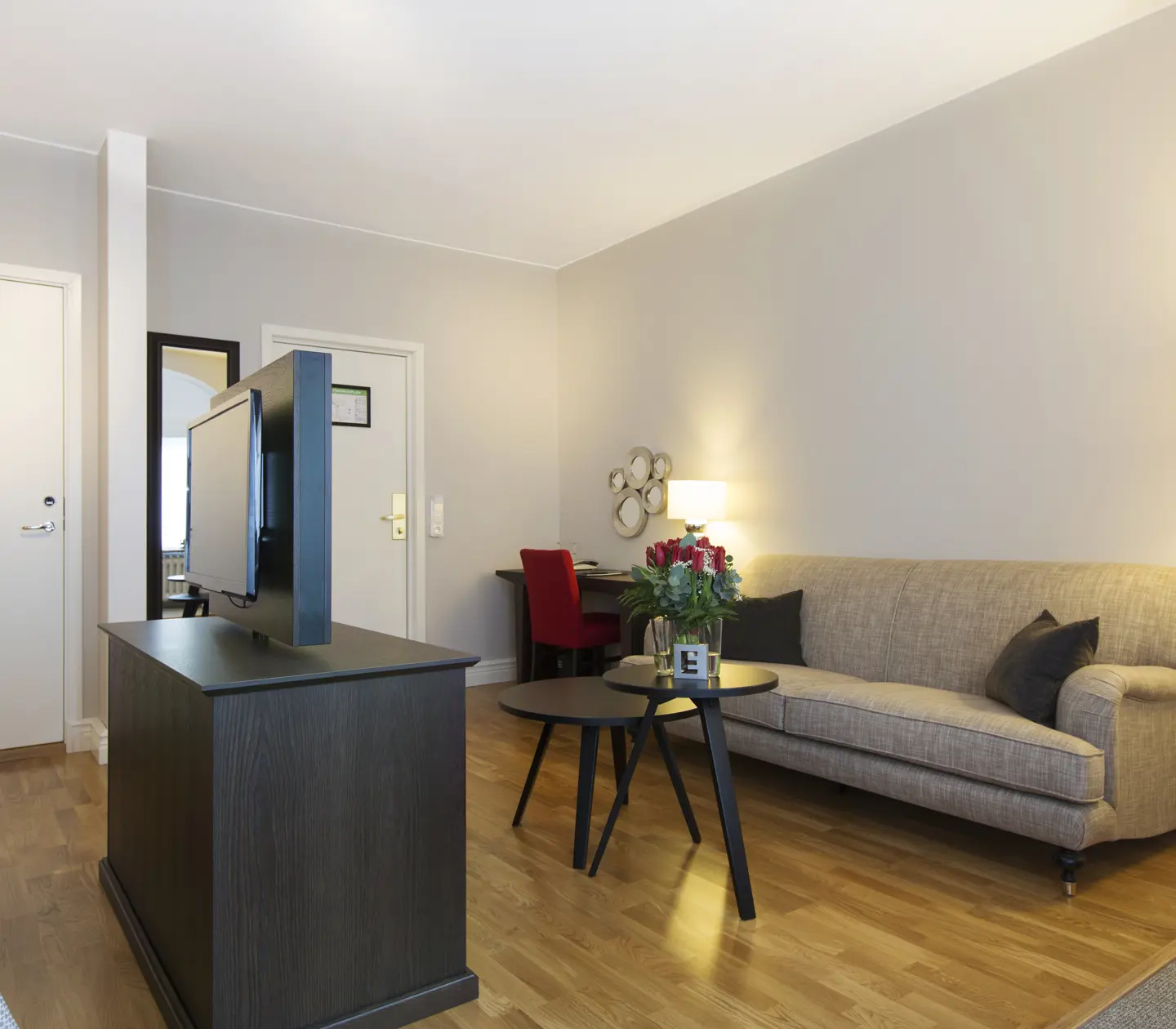 Bright suite with sofa, desk and rose bouquet