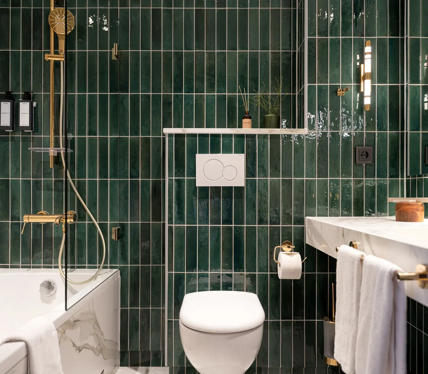Green bathroom with bathtub, toilet, and sink.