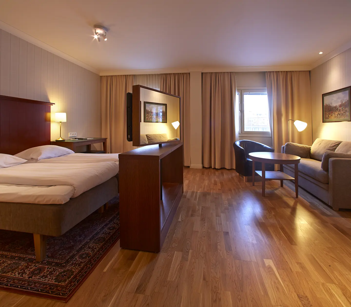 Cozy hotel room with bed, sofa, and window