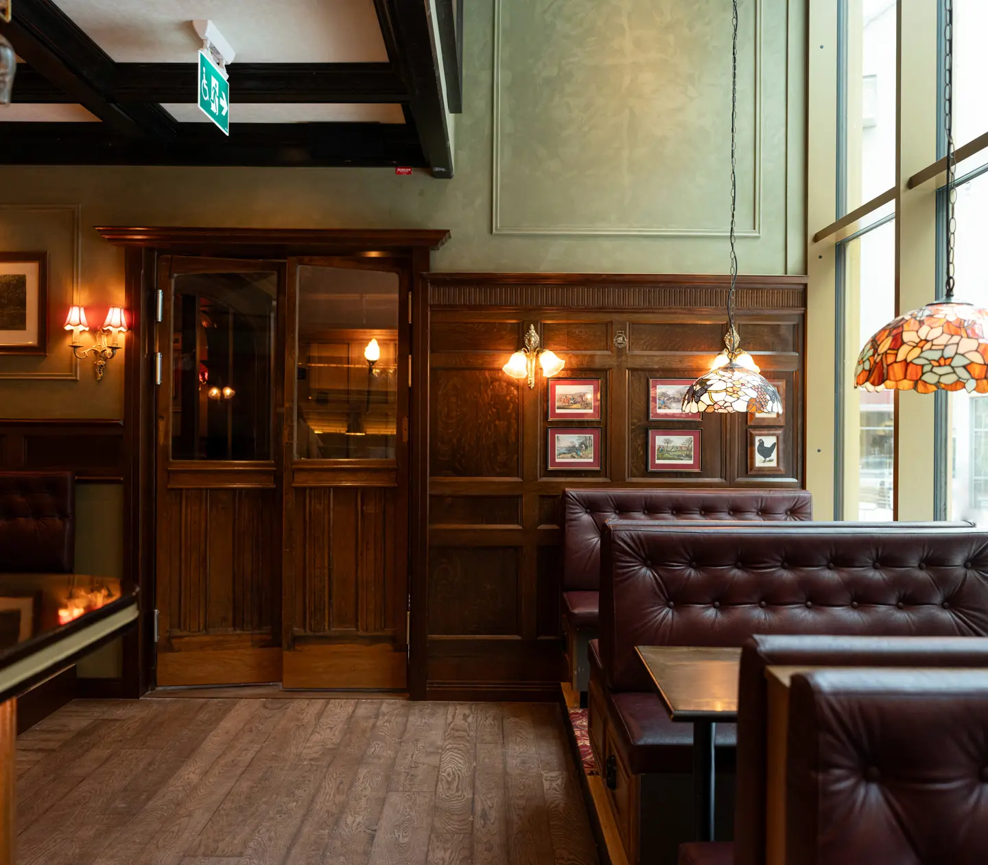 Leather booths at The Bishops Arms with hanging lamps in various colours.
