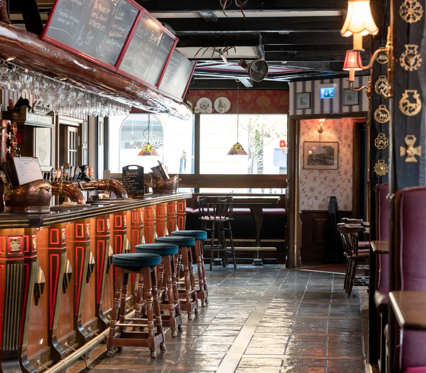 Pub environment with seating, bar and menus on blackboards