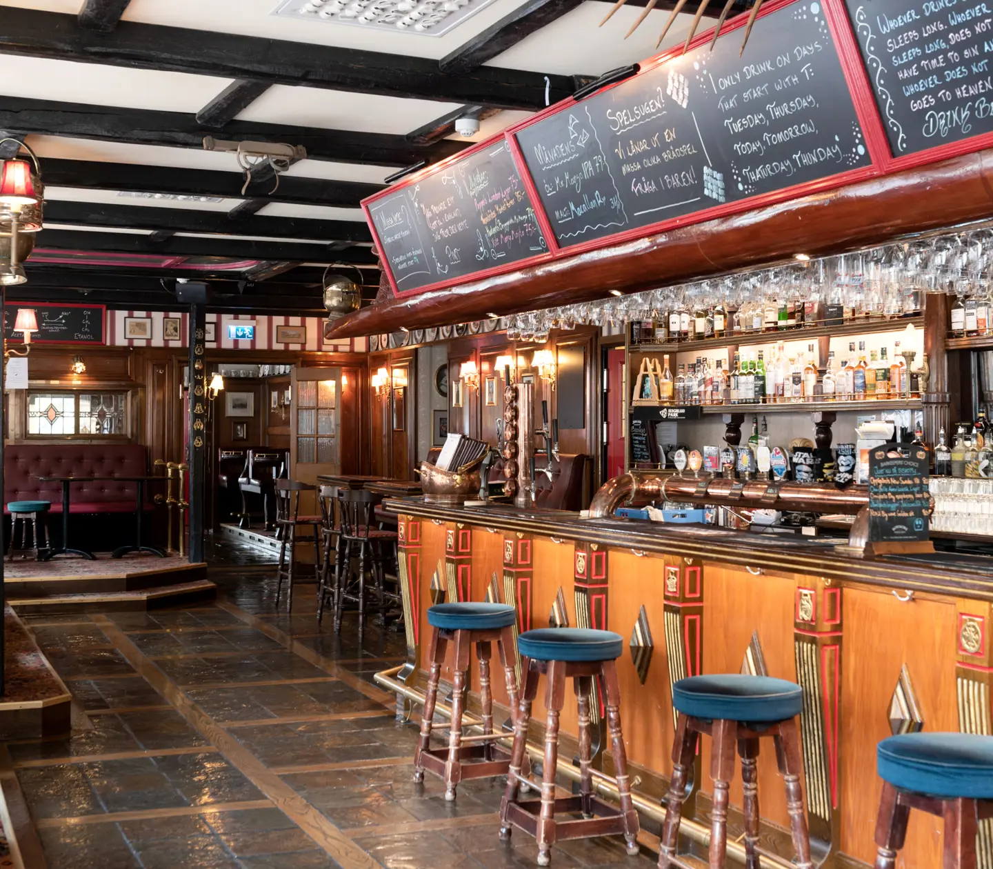 Pub environment with bar, bar stools and menus on blackboards