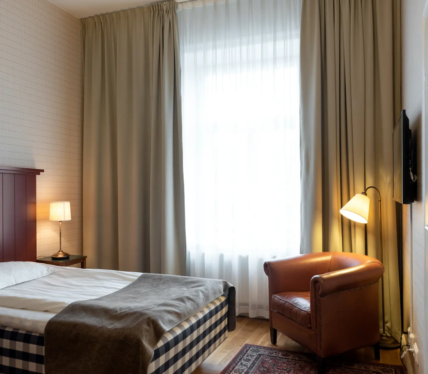 Hotel room with Hästens bed, leather armchair and window