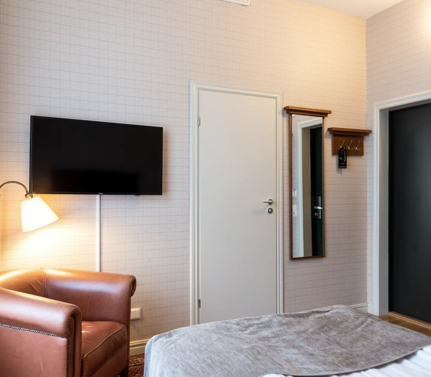 Hotel room with Hästens bed, leather armchair and window