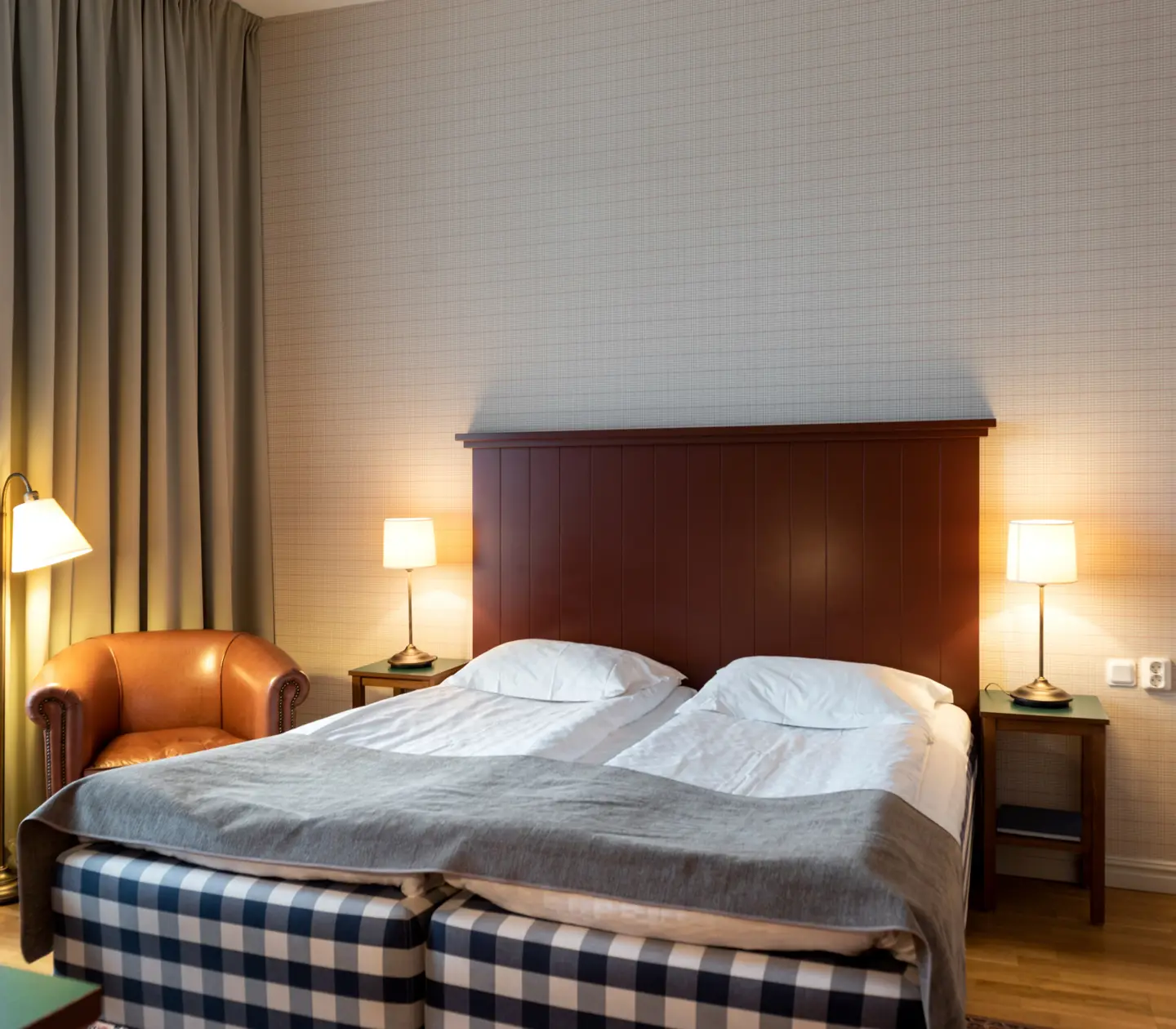 Hotel room with Hästens bed, leather armchair and bedside lamps