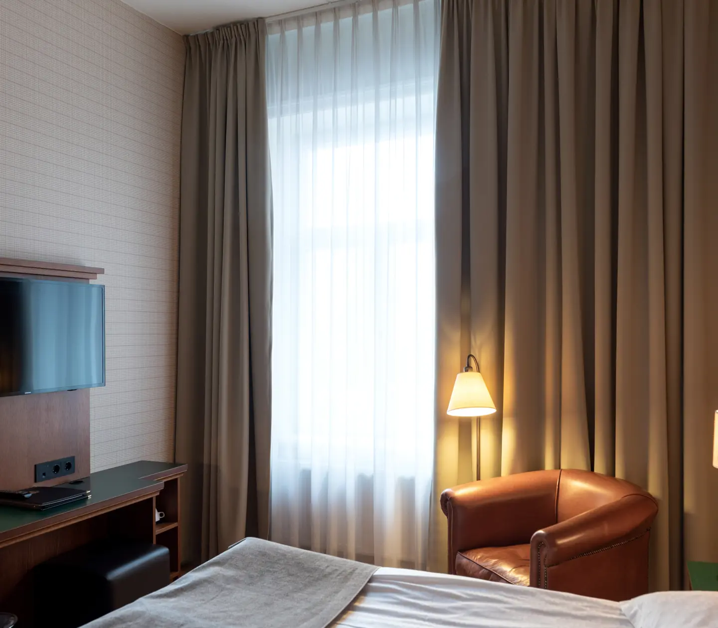 Hotel room with bed, leather armchair and window
