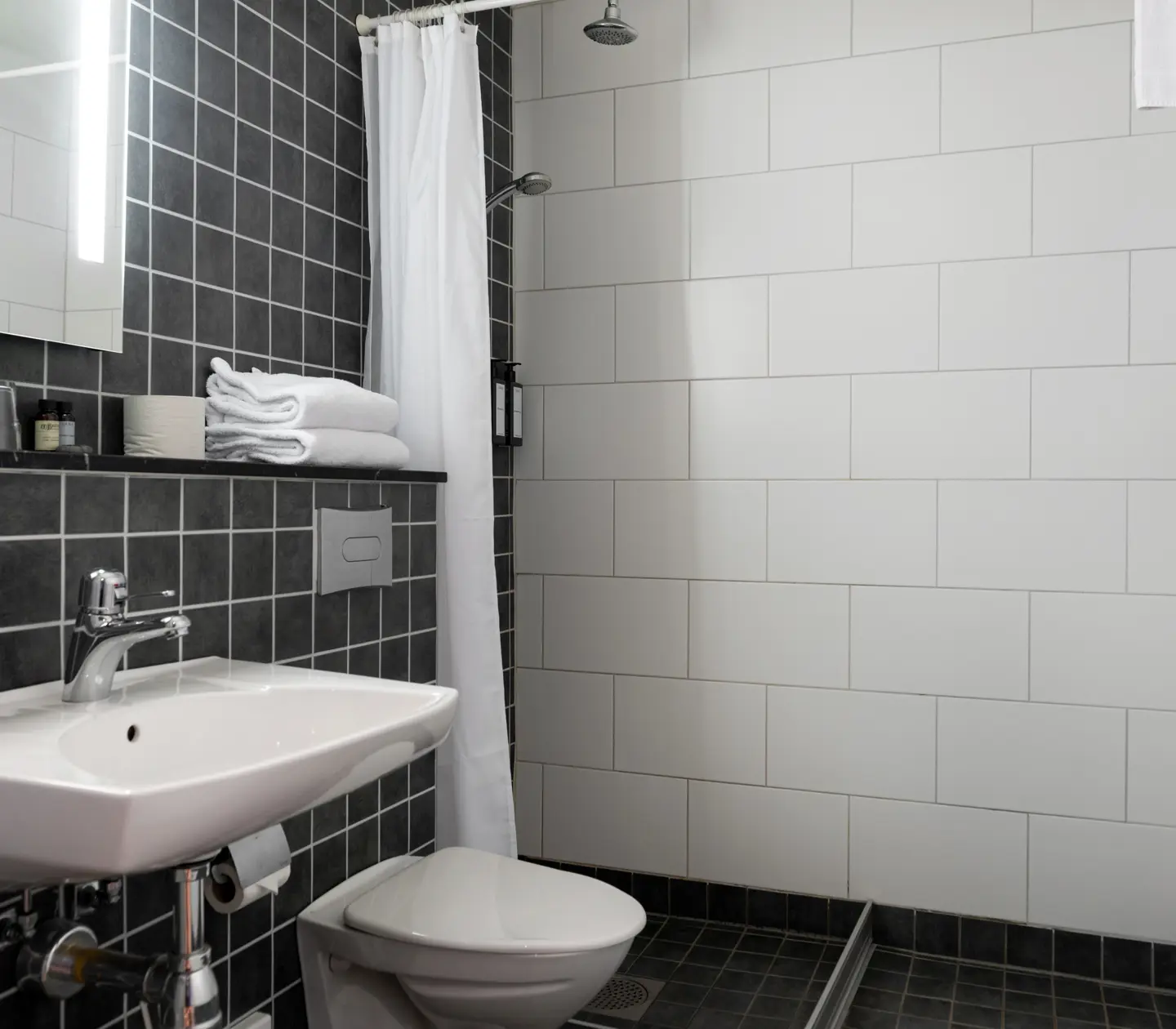 Black and white bathroom with shower, toilet and sink