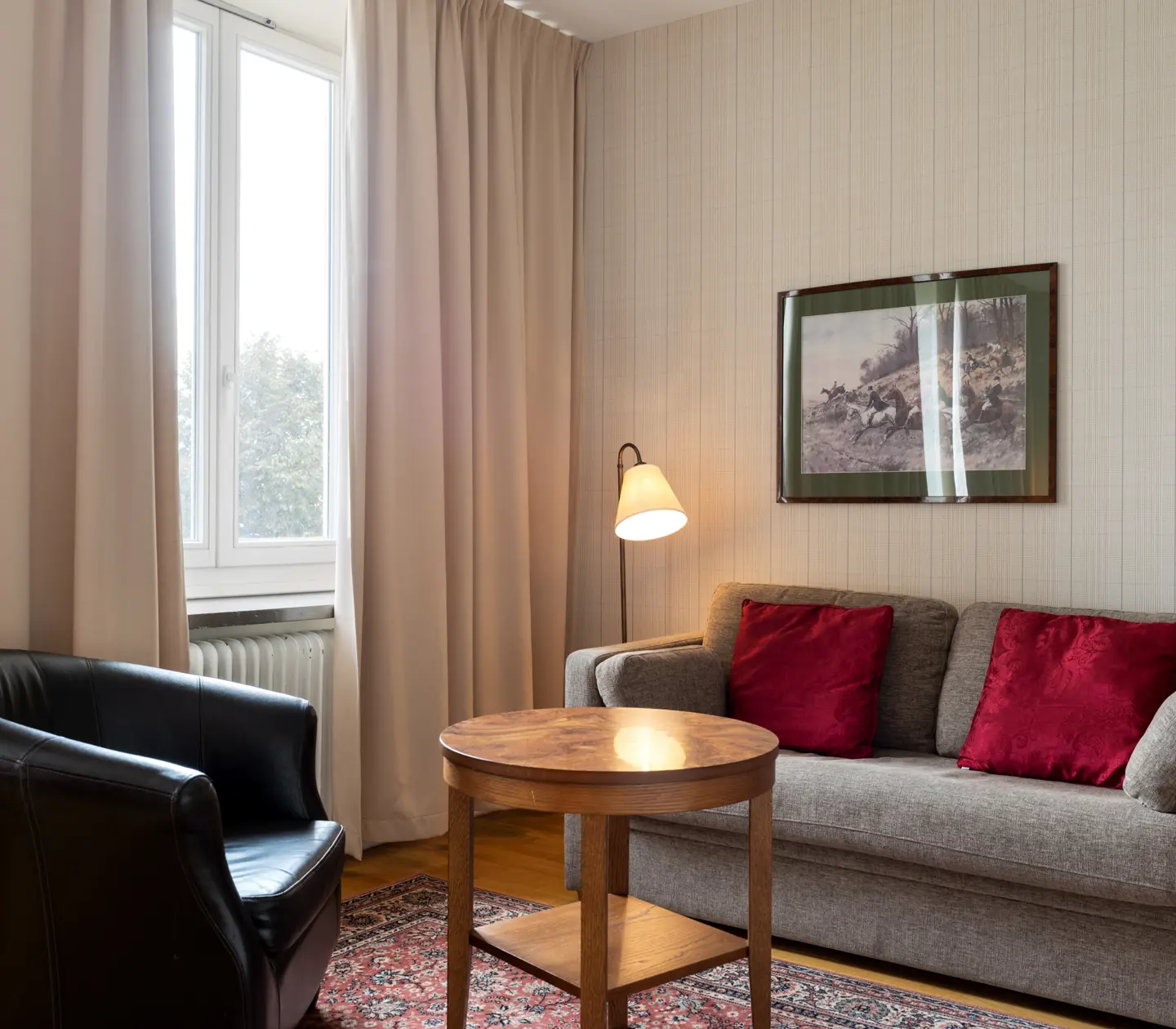 Hotel room with sofa group, floor lamp and window