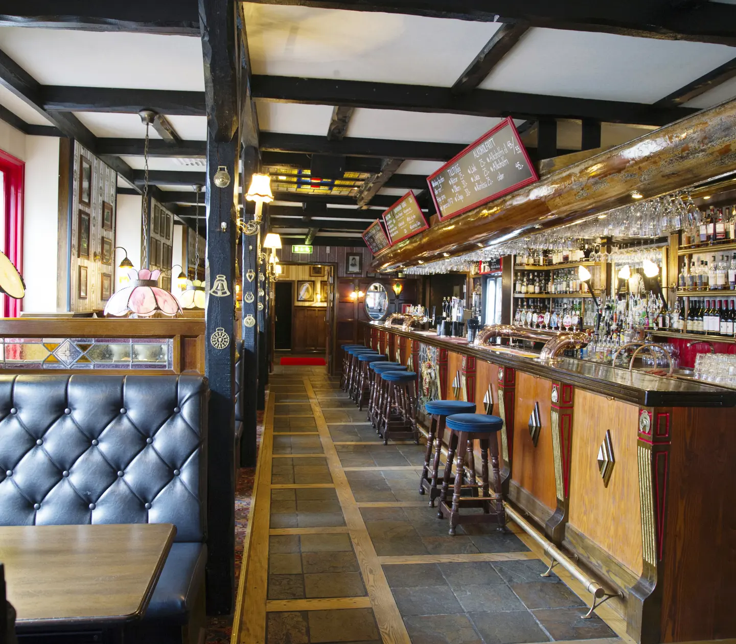 Bar environment with bar counter, bar chairs and menus on blackboards