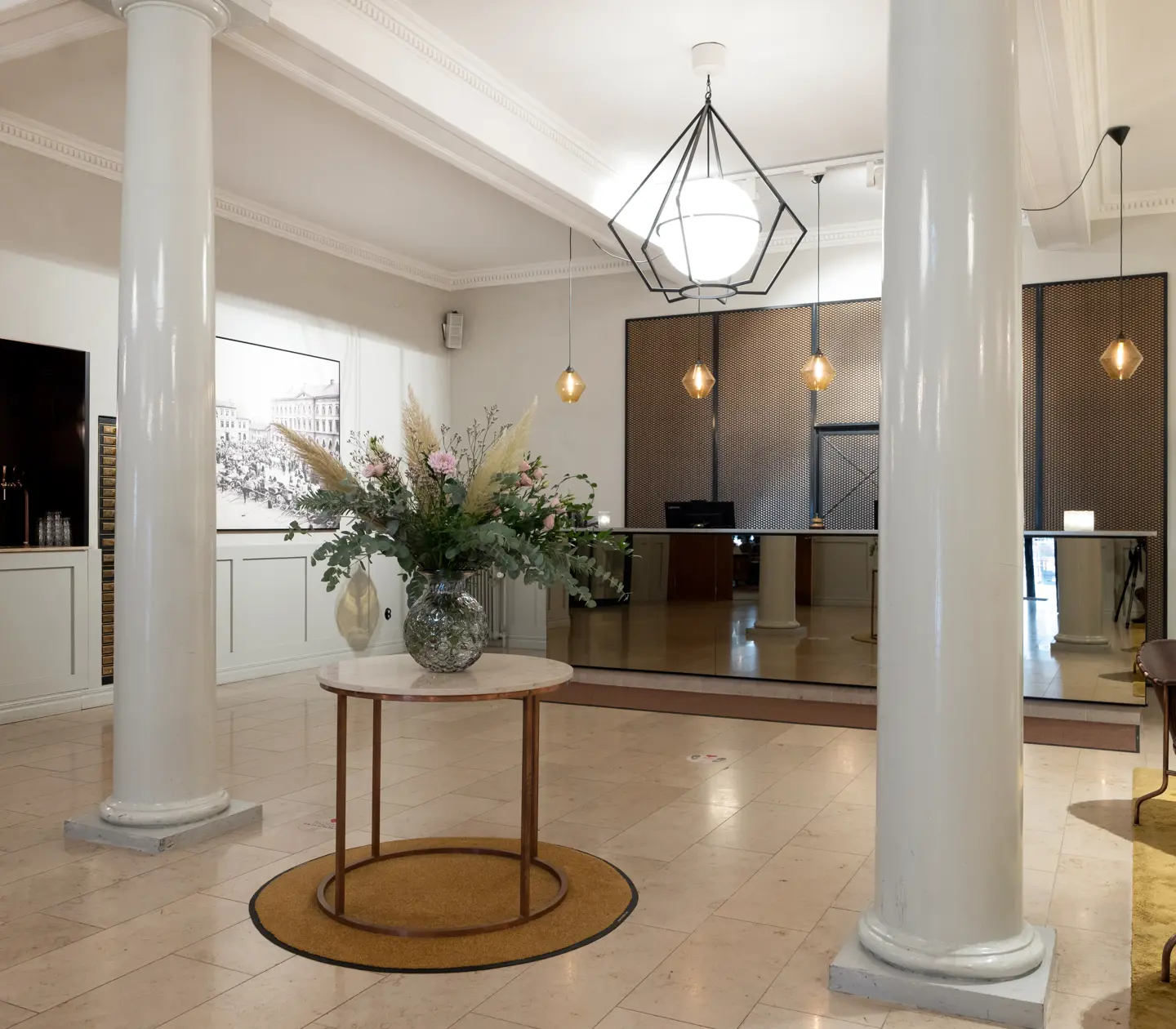 Hotel lobby with large flower bouquet, reception desk and armchairs