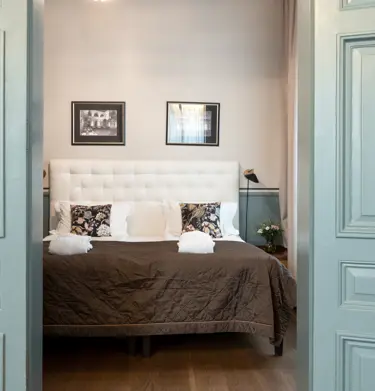 Suite with double bed and open green doors