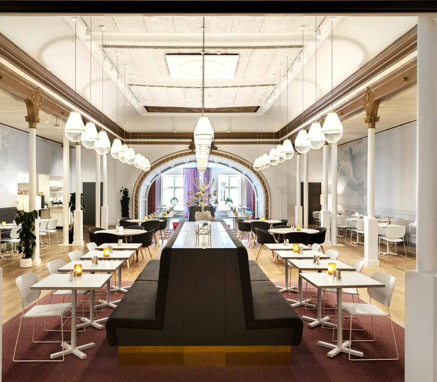 Dining room with high ceiling, dining groups and lamps