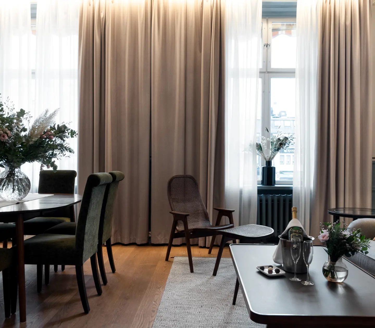 Suite with dining table, seating area and large windows