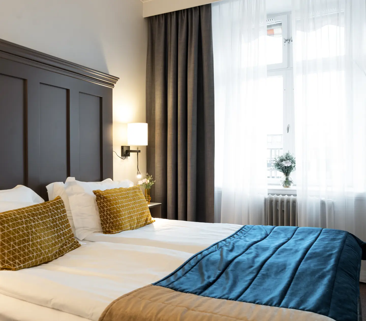 Cozy hotel room with part of a double bed and large window