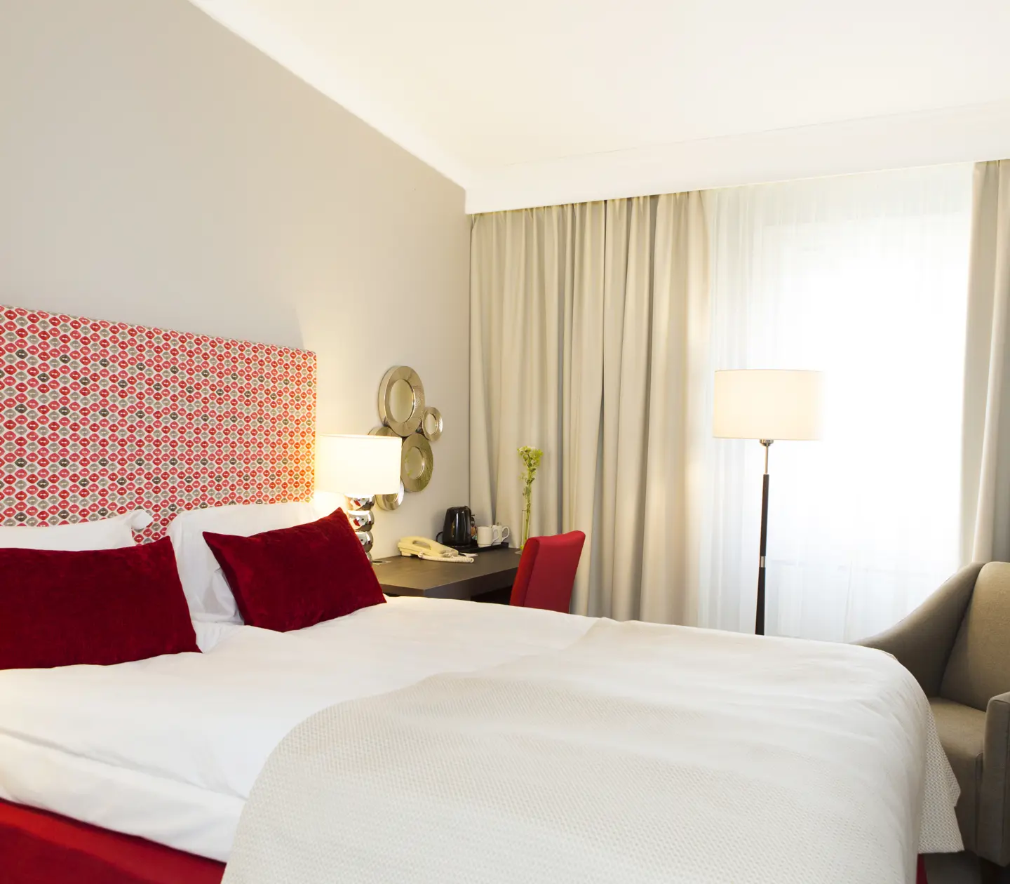 Hotel room with double bed, desk and armchair
